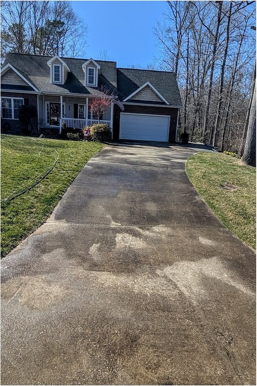 Before power washing: stained driveway with algae and grime